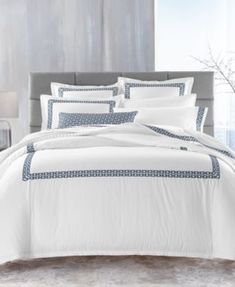 a bed with white and blue comforters in a room