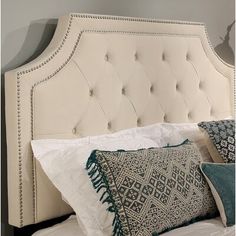 a white headboard with blue and green pillows