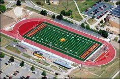 an aerial view of a football field and parking lot