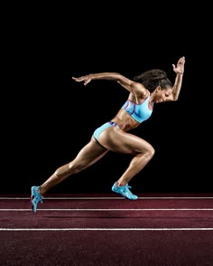 a woman running across a red track