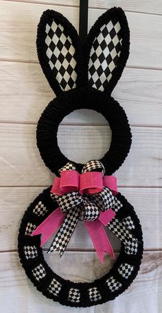 a black and white bunny ears wreath hanging on a wall