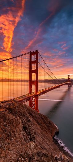 the golden gate bridge in san francisco, california at sunset as seen from across the bay