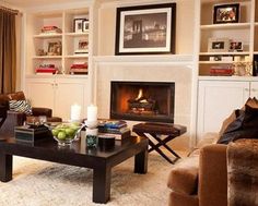 a living room filled with furniture and a fire place in the middle of a room