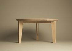 a wooden table sitting on top of a white floor next to a brown wall and chair