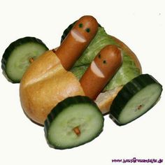 two hotdogs with cucumbers on them are made to look like people