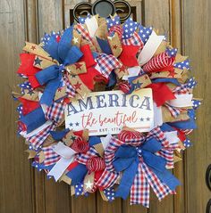 a patriotic wreath with the words america and red, white, and blue bows on it