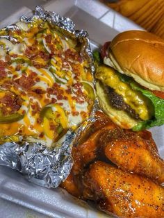 a tray filled with chicken wings, cheeseburger and macaroni and cheese