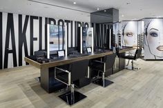 a store with two desks and chairs in front of large wall graphics on the walls