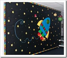 a bulletin board with a rocket ship painted on it's side and stars in the background