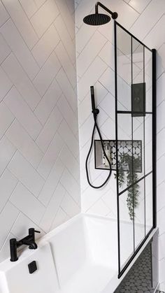 a white bathroom with black fixtures and tile flooring, along with a bathtub