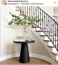 there is a vase with flowers on the table in front of the stair railings