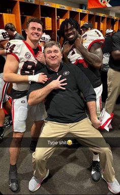 two football players posing for a photo in the locker room with their arms around each other