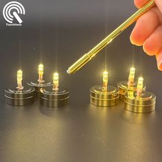 a person is holding a pen in front of some tiny lights on top of each other