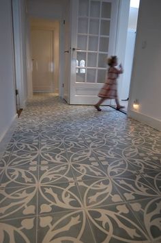 a woman walking down a hallway next to a door