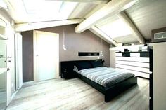 a bedroom with a bed, dresser and skylight in the ceiling is very spacious