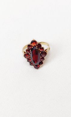 Lovely vintage classic 1930s 8 Kt (333) yellow gold garnet cluster ring. Marquise shape. Ring is  in excellent condition. Ring size 5 (US) - see last photograph Please accept that the actual colour may vary slightly from how it appears on your screen due to photographic lighting sources or your monitor settings. All of our items are either vintage or antique, which means they are rarely in mint condition and will have some wear. We try to describe any flaws that we see but please look at all of Antique Garnet Ring, Ring Marquise, Garnet Ring, Gift Wrapping Services, Garnet Rings, Multi Stone Ring, Red Garnet, Multi Stone, Photographic Lighting