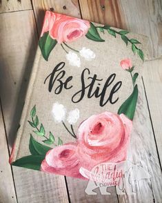 a painted book that says be still with pink flowers on the front and back cover