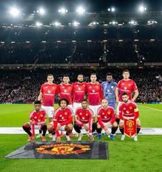 the soccer team is posing for a photo on the field in front of an empty stadium