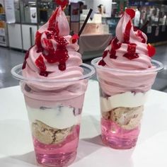 two ice cream sundaes sitting on top of a table next to each other