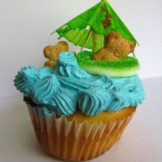 a cupcake with blue frosting and a green sail boat on top