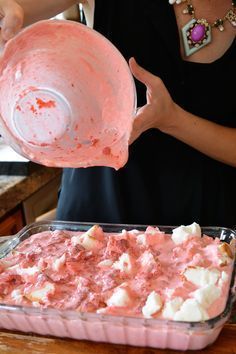 a woman is pouring something into a dish