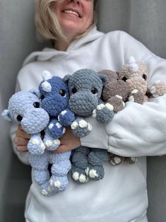 a woman is holding several stuffed animals in her hands