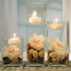 three candles are sitting in glass vases with teddy bears