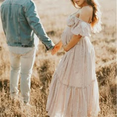 a man and woman holding hands in a field