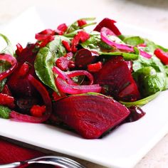 a white plate topped with beets and spinach