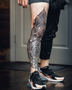 a man's leg with tattoos on it