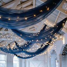 a room filled with lots of lights and blue draping hanging from the ceiling