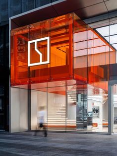 an orange and white building with people walking by