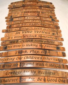 a stack of wooden wine barrels with writing on them sitting next to each other in front of a white wall