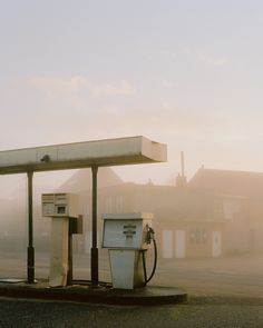 two old gas pumps sitting on the side of a road