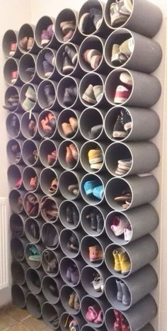 an organized shoe rack with many pairs of shoes on it and several rows of grey plastic cups