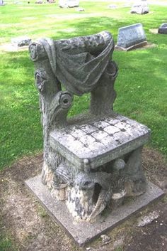 a stone bench sitting on top of a lush green field