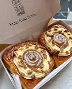 two cinnamon buns in a box on a table