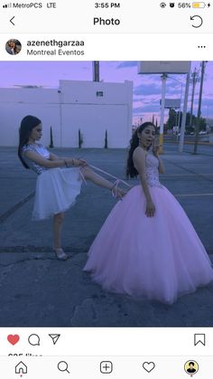 two girls in dresses holding hands and posing for the camera