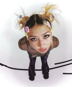 a woman with her hair tied back and looking at the camera while standing in front of a white background