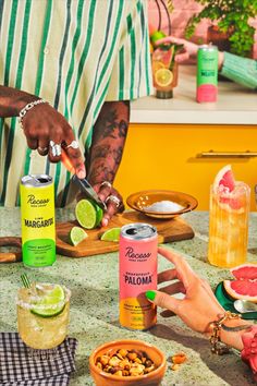 a man cutting up food on top of a table next to other foods and drinks