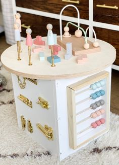 a toy chest with wooden pegs and knobs on it in front of a dresser