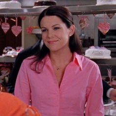 a woman standing in front of a table with cake on it