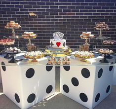 a table topped with lots of desserts and pastries on top of white blocks