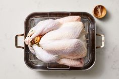 a raw chicken sitting on top of a metal pan