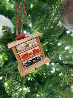 a christmas ornament hanging on a tree with other ornaments in front of it