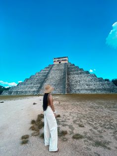 a woman standing in front of an ancient pyramid