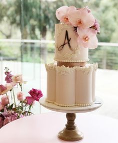 a three tiered cake with pink flowers on top