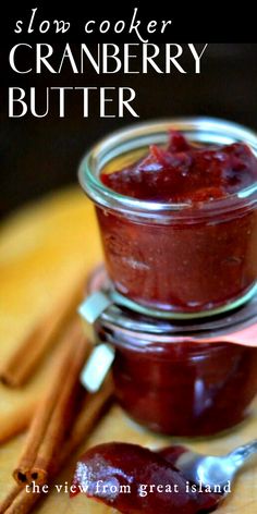 a jar filled with cranberry butter next to cinnamon sticks