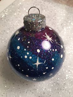 a blue ornament with white stars on it sitting on a table next to some glitter