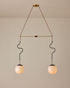 two light fixtures hanging from a ceiling in a room with white walls and flooring